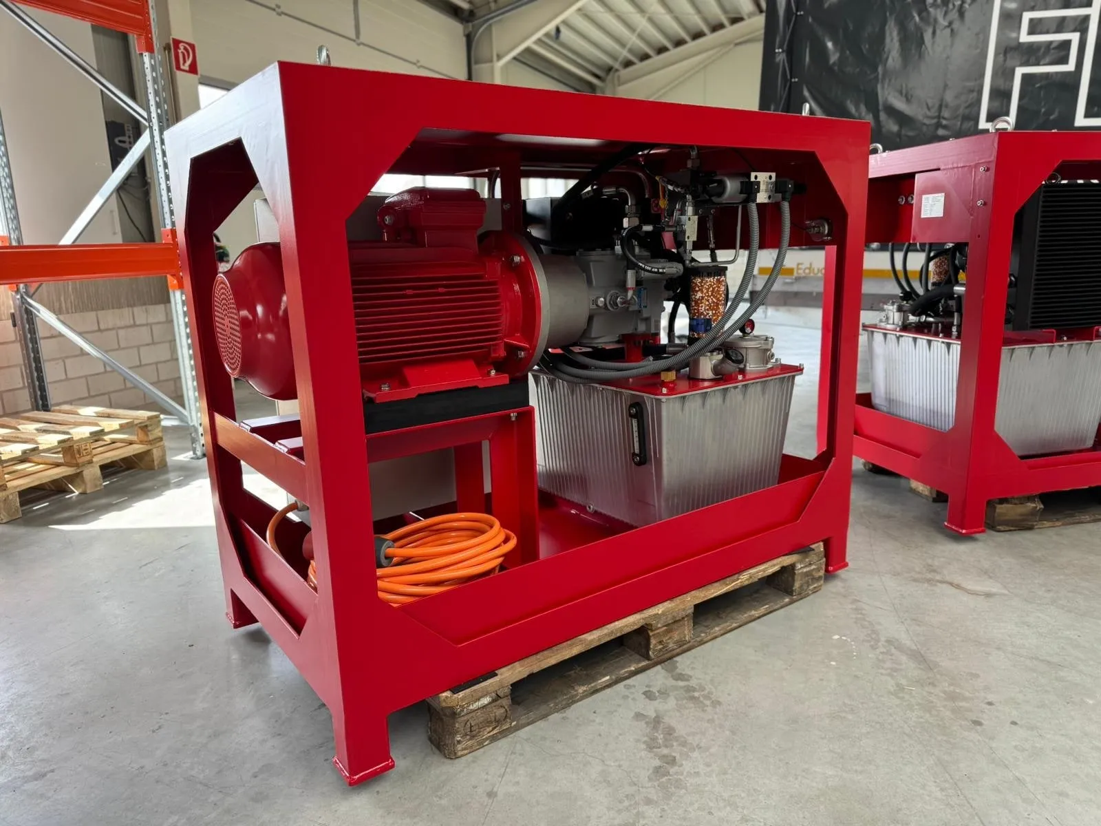 Zwei baugleiche rot lackierte Hydraulikaggregate von FPS Hydraulik im Transportrahmen, mit Elektromotor, Ventiltechnik, Filter und Aluminiumtank, in der Werkstatt in Holdorf
