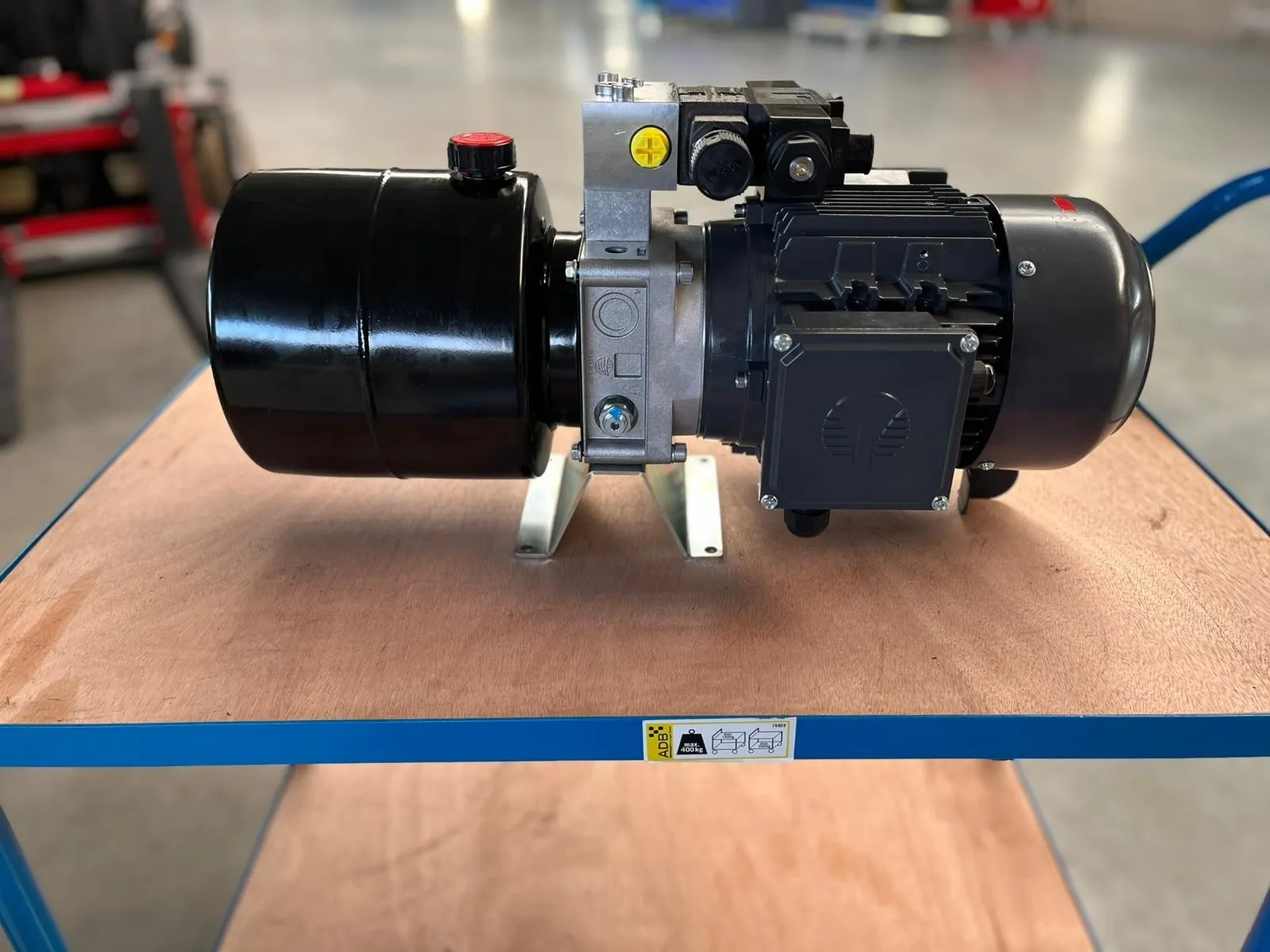 Kompaktes Hydraulikaggregat mit schwarzem Behälter, Ventilblock und Drehstrommotor auf dem Montagetisch