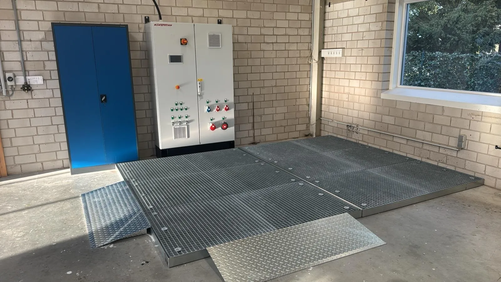 Prüffläche aus Gitterrost mit Schaltschrank des Elektroprüfstands bei FPS Hydraulik