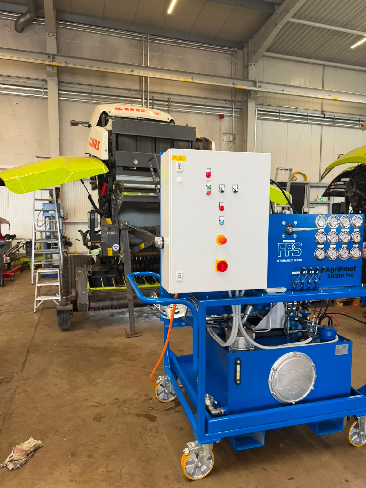 L'AgriProof 60/210 Pro alimente une machine agricole en hydraulique dans un atelier.